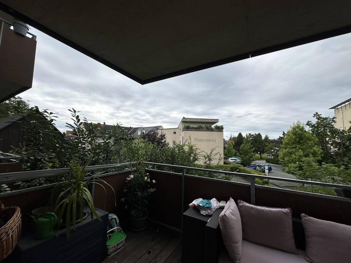 Entspannender Balkon mit bequemen Sitzmöbeln und Blick auf die grüne Umgebung.