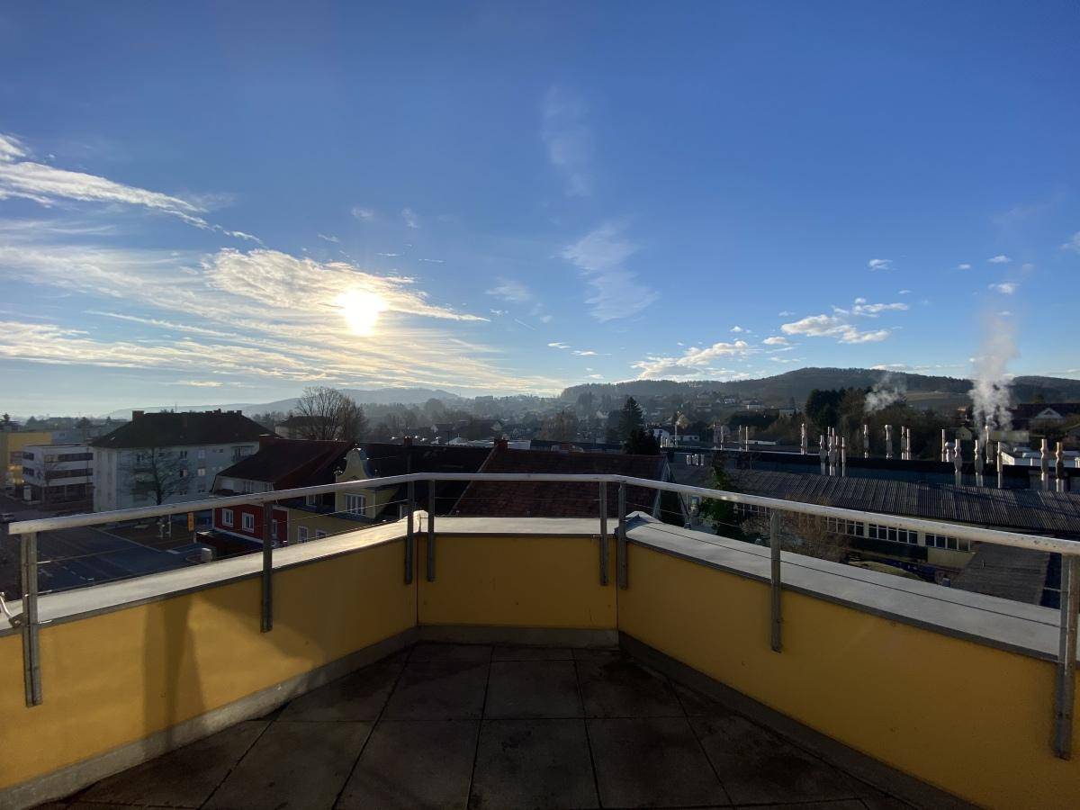 Weitläufiger Ausblick von einem Balkon über die Stadt und die umliegende Hügellandschaft.