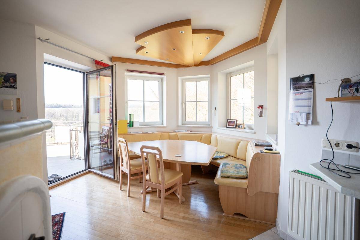 Gemütlicher Essbereich mit Eckbank, Holztisch und Zugang zu einem Balkon mit Weitblick.