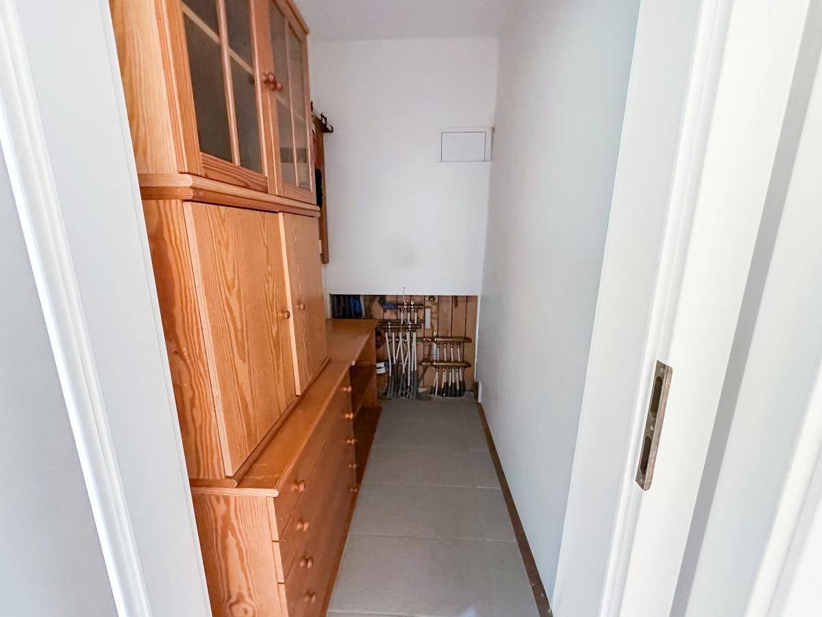 Praktischer Abstellraum mit Holzregalen und sichtbaren Installationen für zusätzlichen Stauraum.