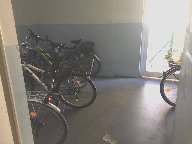 Gemeinschaftlicher Fahrradraum mit mehreren abgestellten Fahrrädern und Tageslicht.