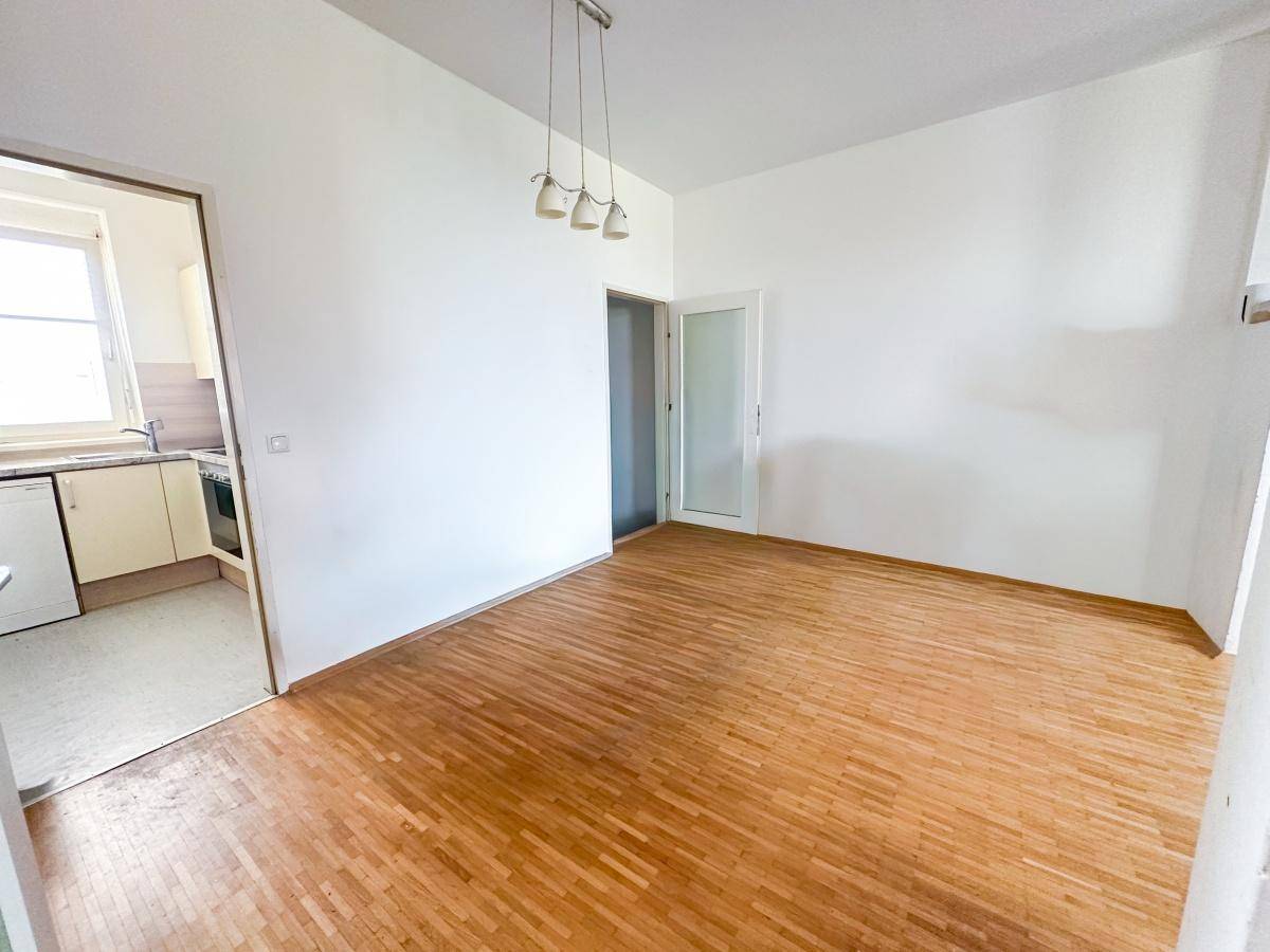 Heller Essbereich mit Parkettboden und direktem Zugang zur Küche.