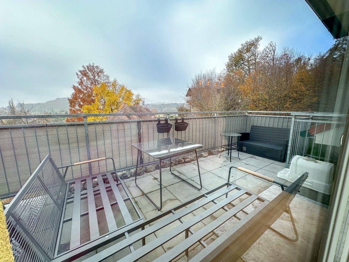 Balkon mit Sitzgelegenheiten und weitem Blick über die herbstliche Landschaft.