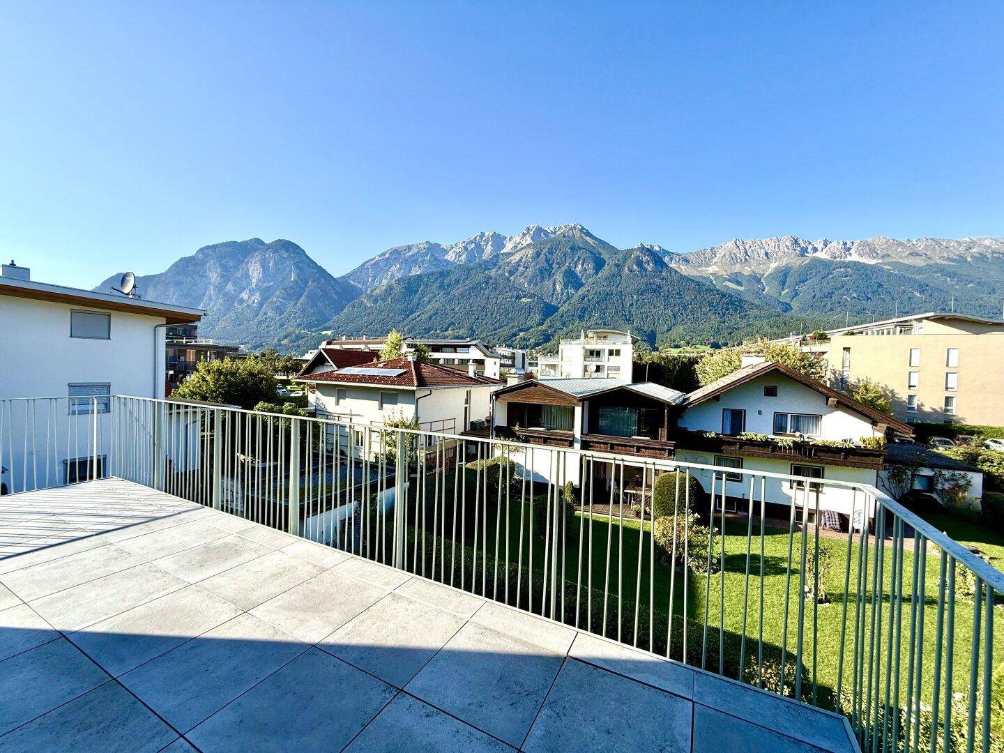 Geräumige Terrasse mit Fliesenboden und weitem Blick auf die umliegende Berglandschaft.