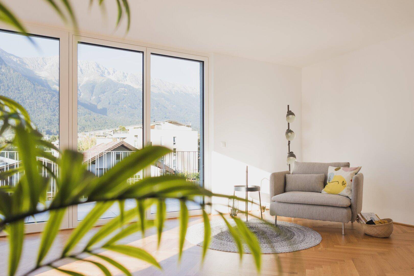 Gemütliches Wohnzimmer mit Bergblick durch große Fenster und modernem Interieur.