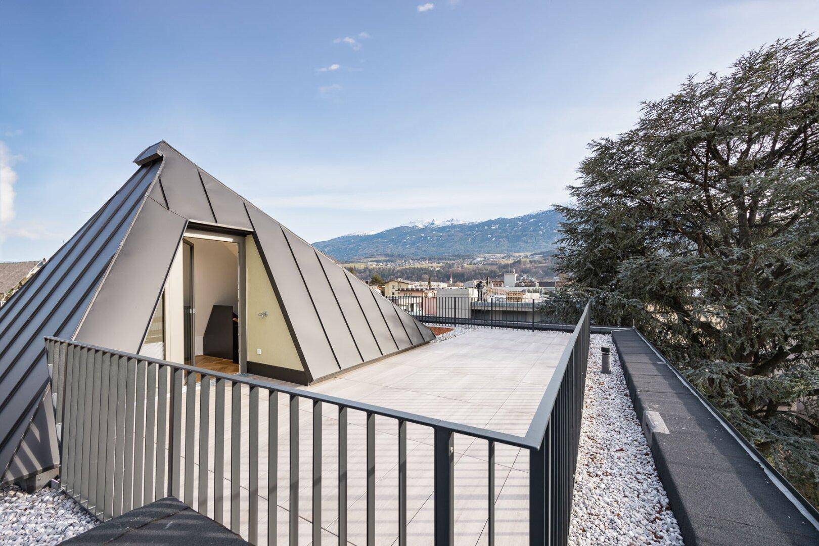 Geräumige Dachterrasse mit moderner Architektur und weitem Blick über die Landschaft.