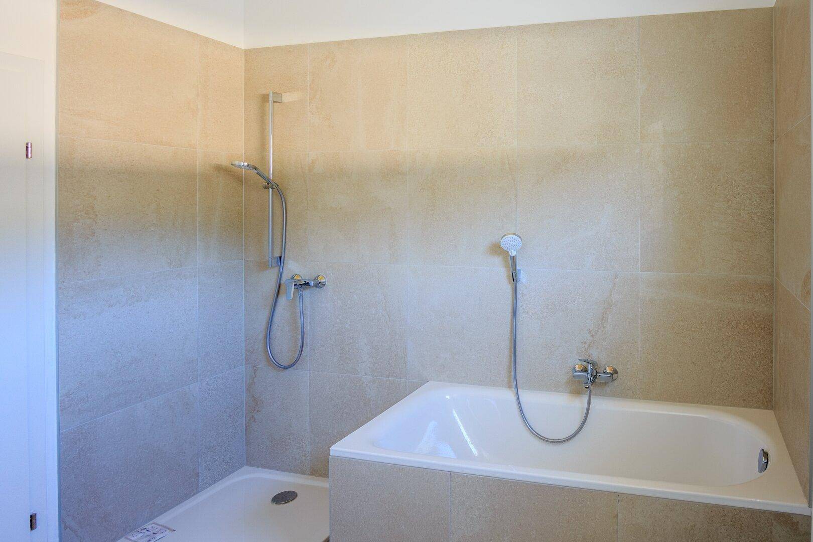 Modernes Badezimmer mit beigefarbenen Fliesen, Badewanne und Dusche.