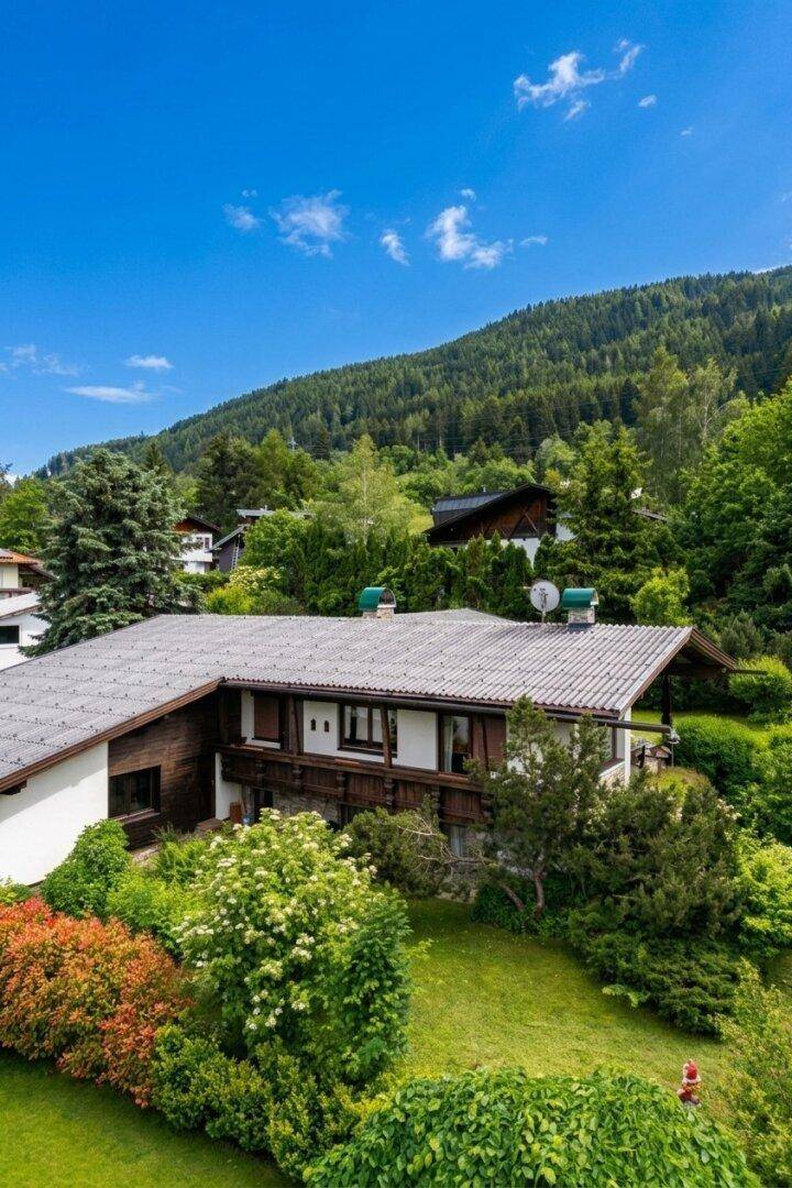 Haus in idyllischer Berglandschaft mit viel Grün und traditionellen Architekturelementen.