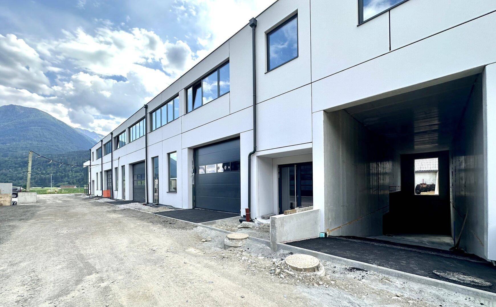 Lange Reihe von Garageneinfahrten und Fenstern an der Seite des modernen Neubaus.