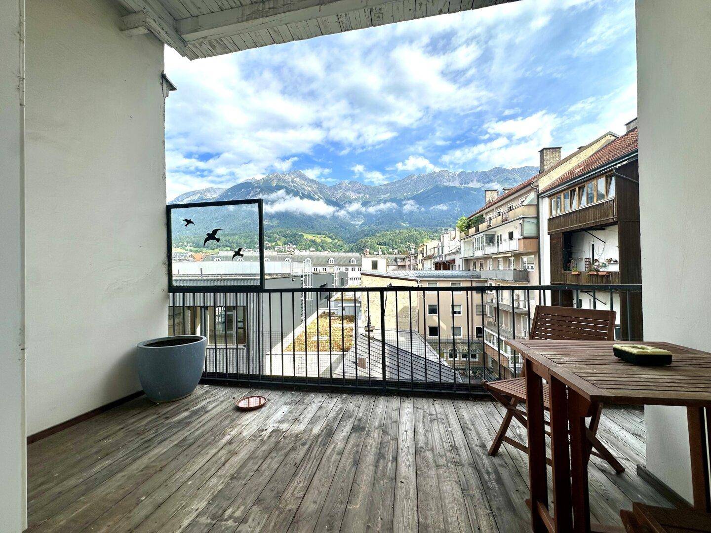 Balkon mit Holzboden und atemberaubendem Blick auf die umliegende Berglandschaft.