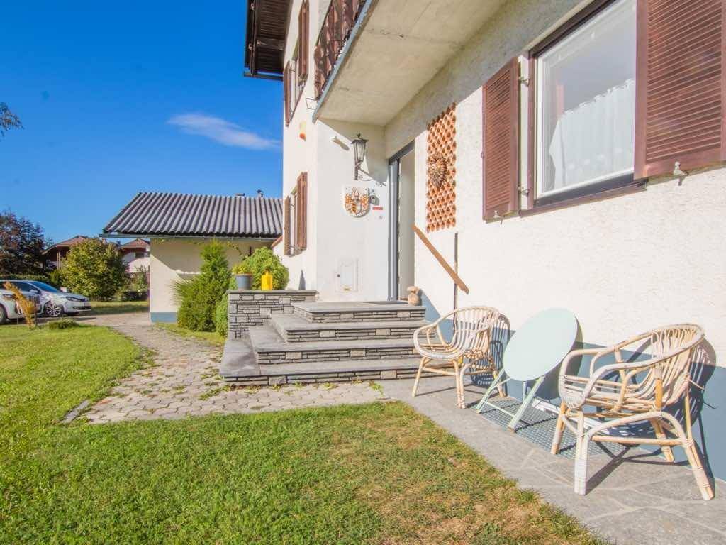Hauseingang mit Steintreppe und kleiner Sitzgelegenheit im Vorgarten.