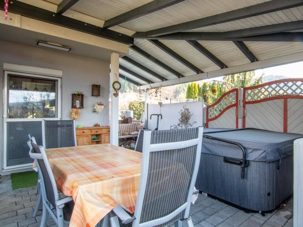 Überdachte Terrasse mit Essbereich im Freien und integriertem Whirlpool.