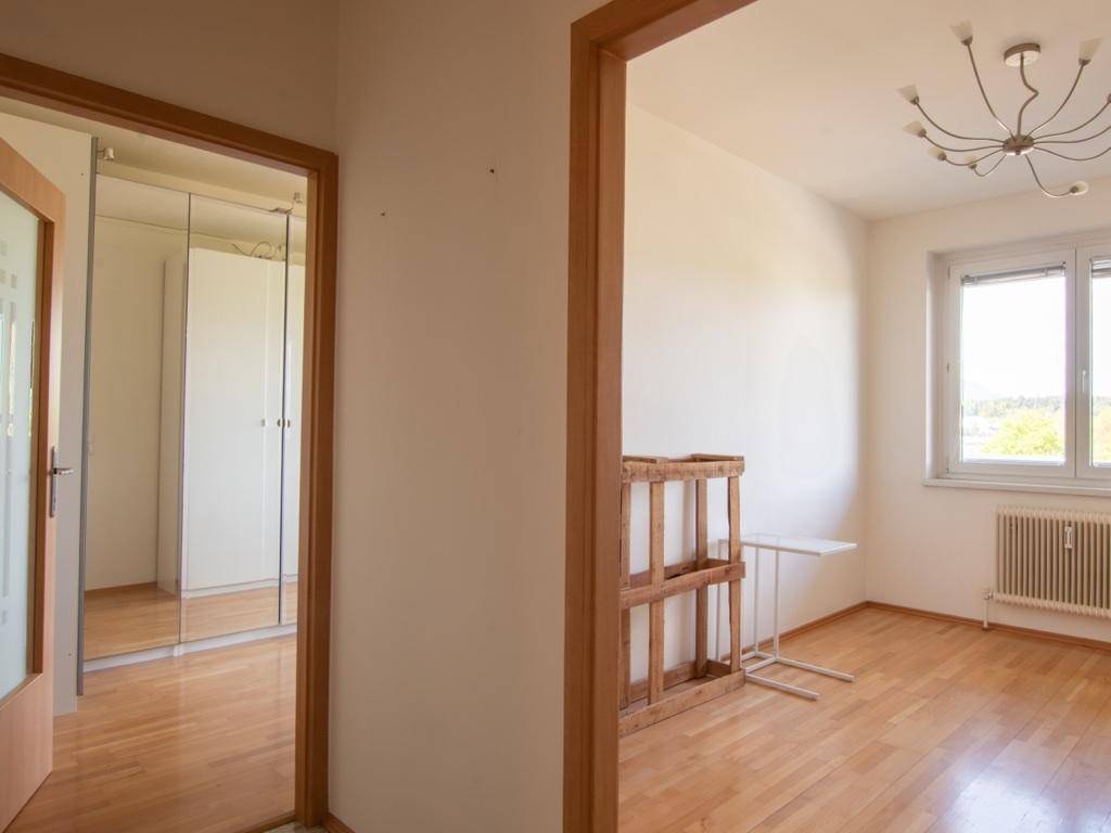 Heller Flur mit Holztüren und Zugang zu einem weiteren Zimmer.
