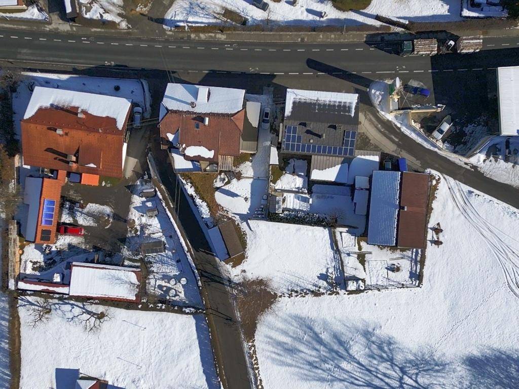 Luftaufnahme des Anwesens und der umliegenden Gebäude in einer schneebedeckten Landschaft.