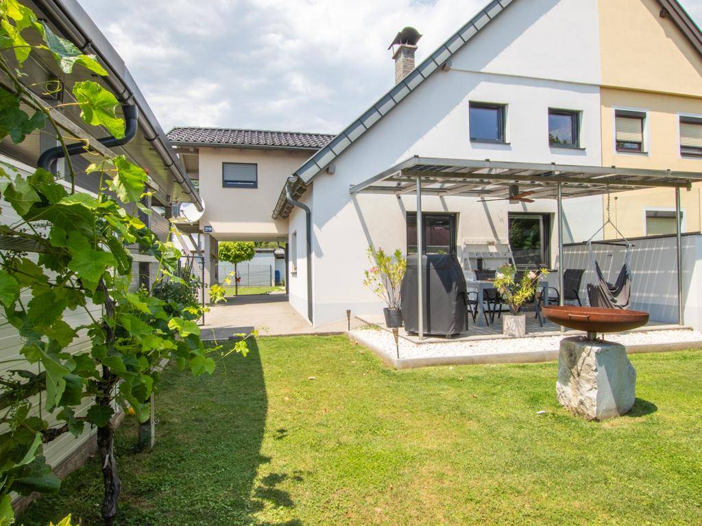 Gepflegter Gartenbereich mit überdachter Terrasse, Grillplatz und Feuerstelle.