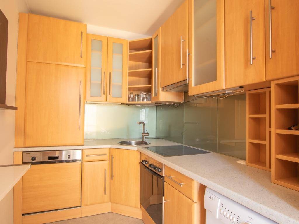 Funktionale Küche mit Holzschränken, integrierten Geräten und hellem Arbeitsbereich.