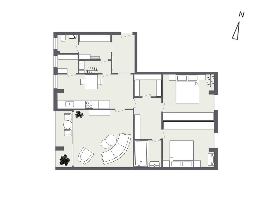 Grundriss einer Wohnung mit offenem Wohnbereich, zwei Schlafzimmern und einem Balkon.