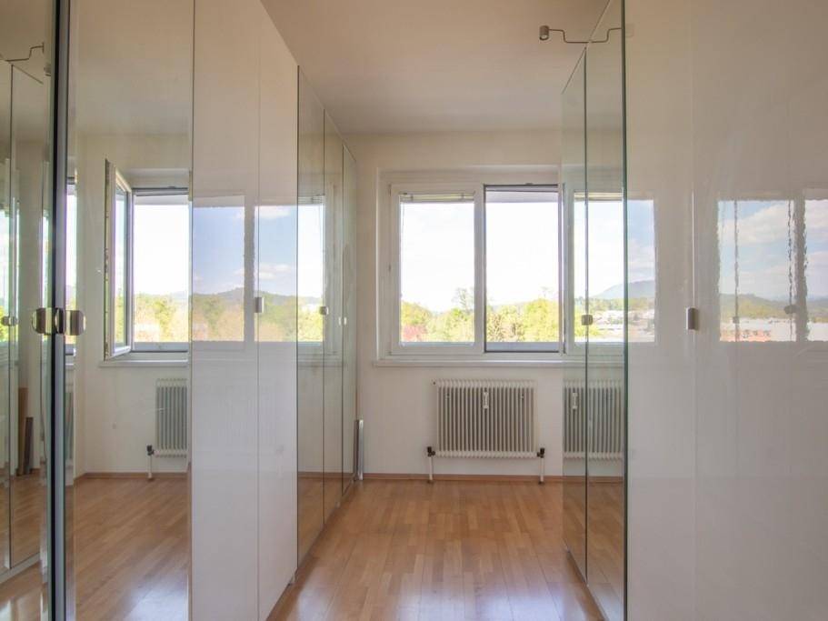 Zimmer mit Spiegelschränken, Parkettboden und Fenstern mit Weitblick.