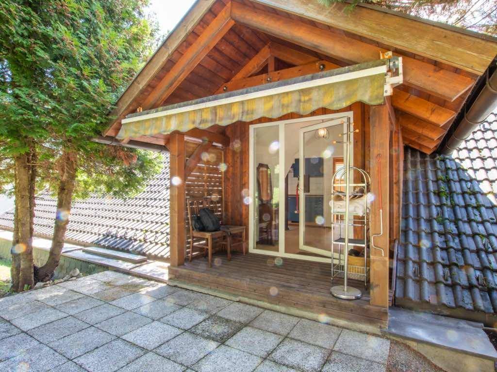 Überdachte Terrasse mit Holzbalken, Fliesenboden und Markise, ideal für entspannte Stunden im Freien.