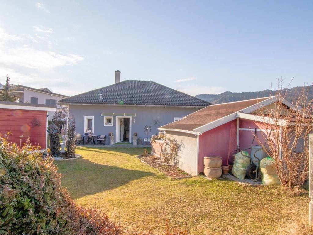 Rückansicht des Hauses mit großem Garten und zwei praktischen Gartenhäusern.