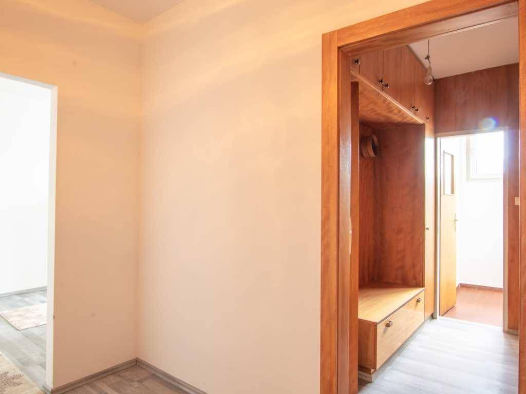 Heller Flur mit integrierter Garderobe aus Holz, die praktischen Stauraum bietet.