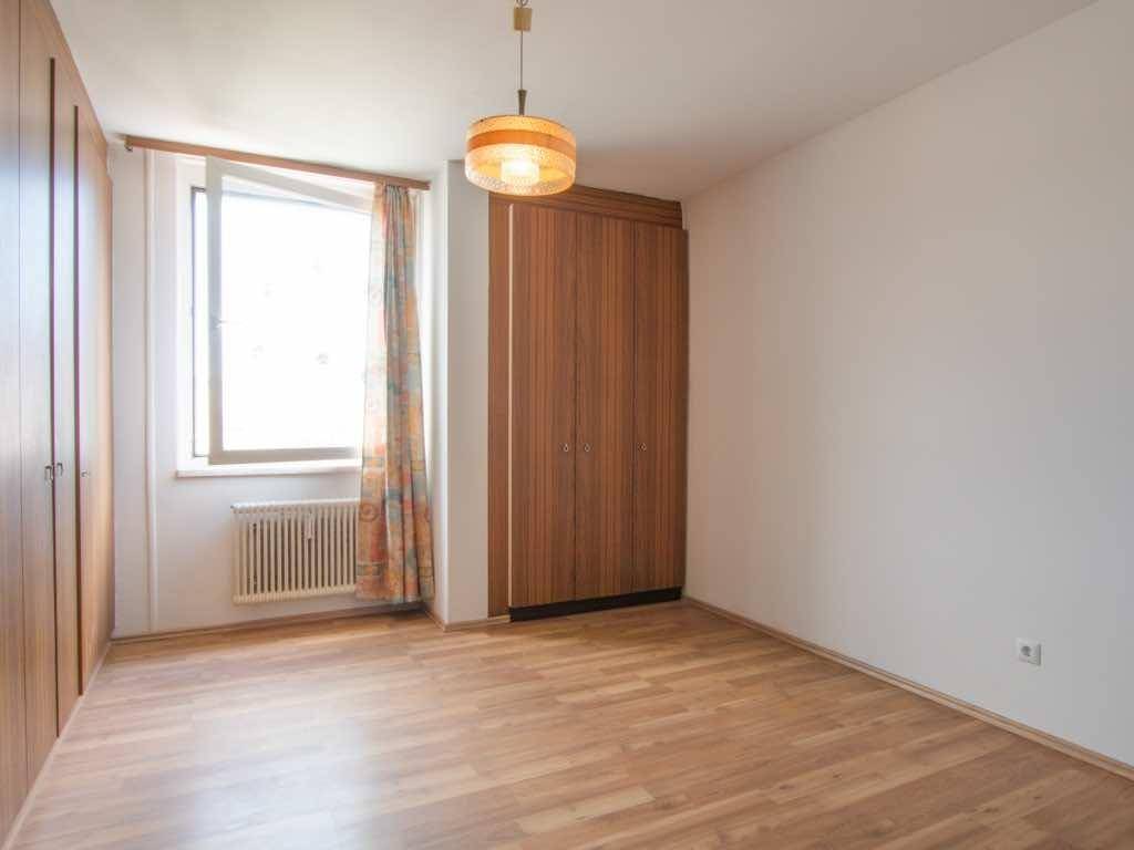 Helles Zimmer mit Holzboden und praktischen Einbauschränken, ideal als Schlaf- oder Arbeitszimmer.