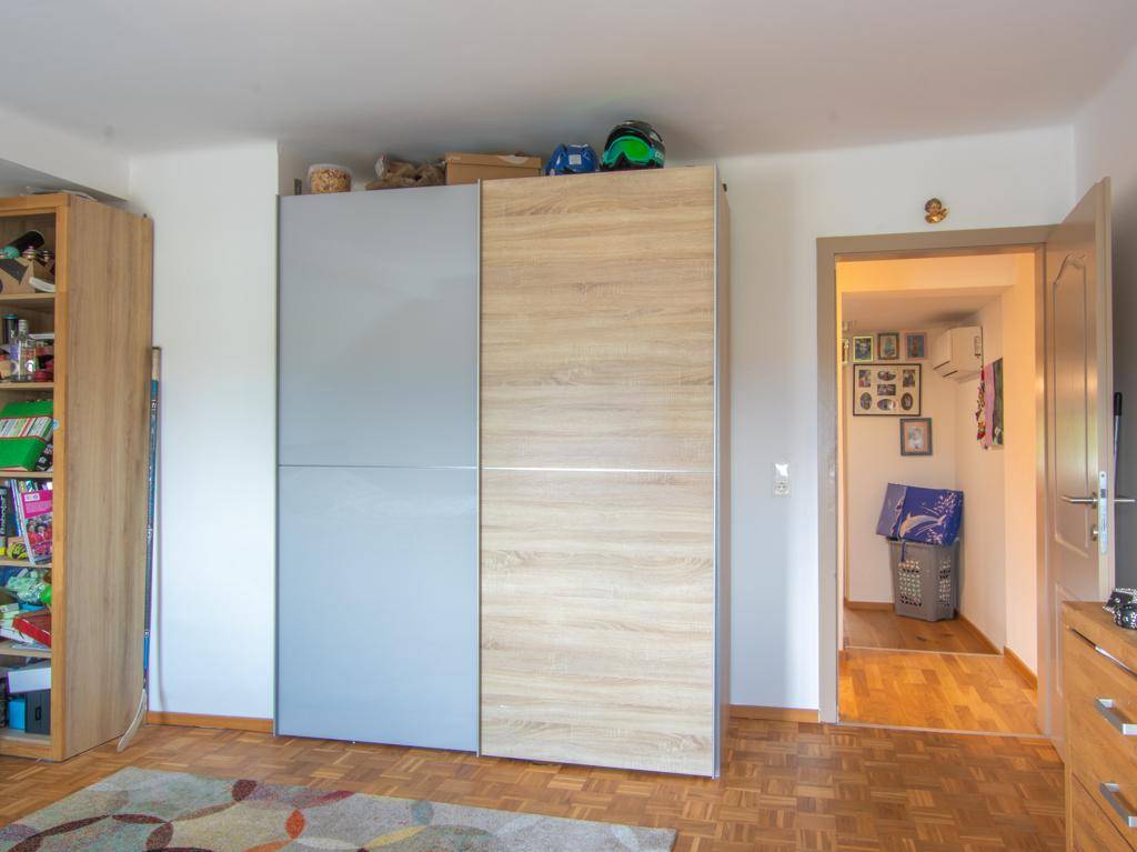 Schlafzimmer mit Einbauschrank und Zugang zu einem weiteren Raum.