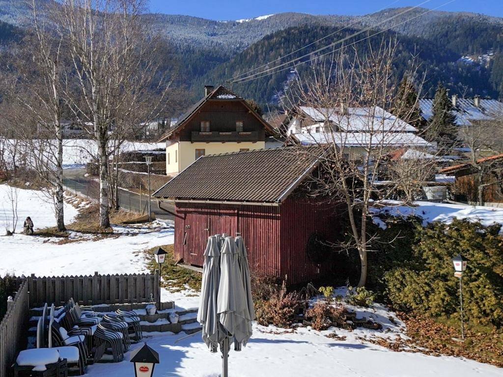 Weitläufiger Blick auf die schneebedeckte Landschaft mit Bergen und umliegenden Häusern.