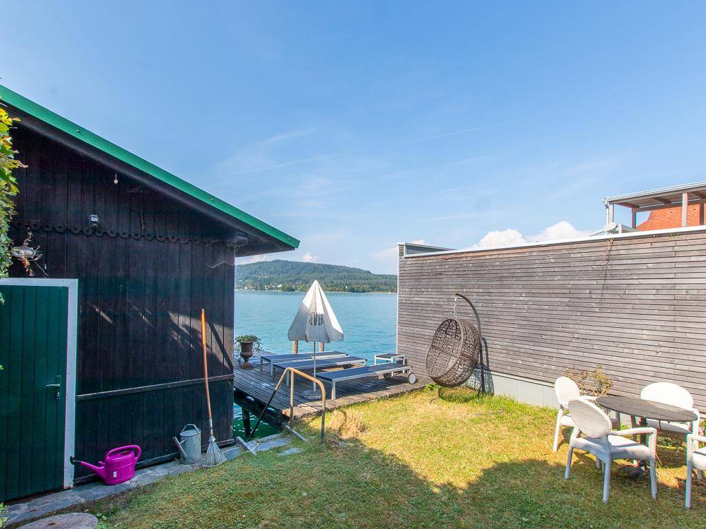 Kleiner Gartenbereich am Seeufer mit Sitzgelegenheiten und weitem Blick über den See.
