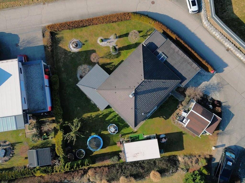 Detaillierte Luftaufnahme des Hauses mit Garten, Trampolin und Nebengebäuden.