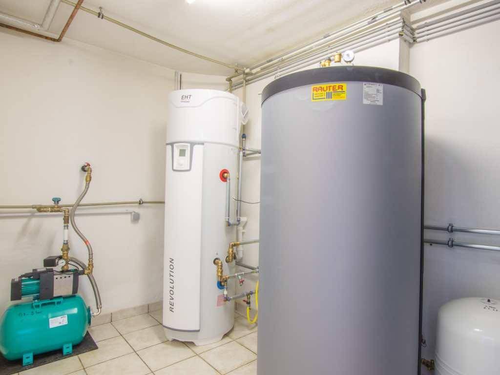 Heizungsraum mit modernen Warmwasserspeichern und Pumpen, sauber und funktional.