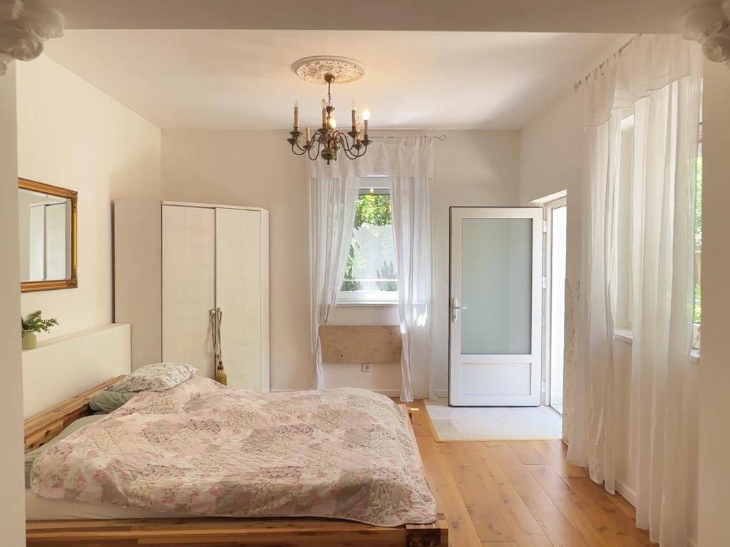 Gemütliches Schlafzimmer mit Holzbett, weißem Kleiderschrank und hellem Holzboden.