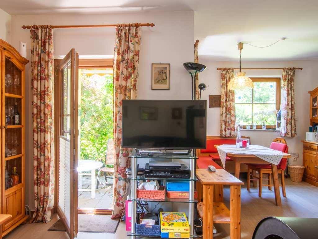 Heller Wohn-Essbereich mit Zugang zur Terrasse und traditionellen Möbeln.