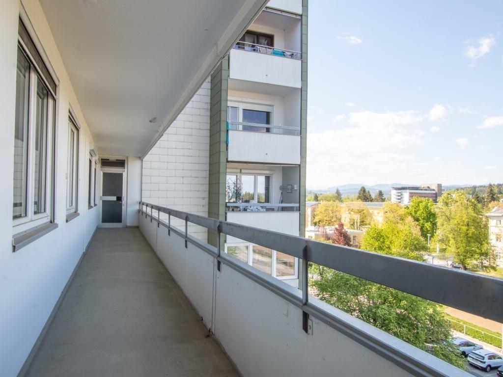 Langer Balkon mit Metallgeländer und weitem Blick über die Umgebung.