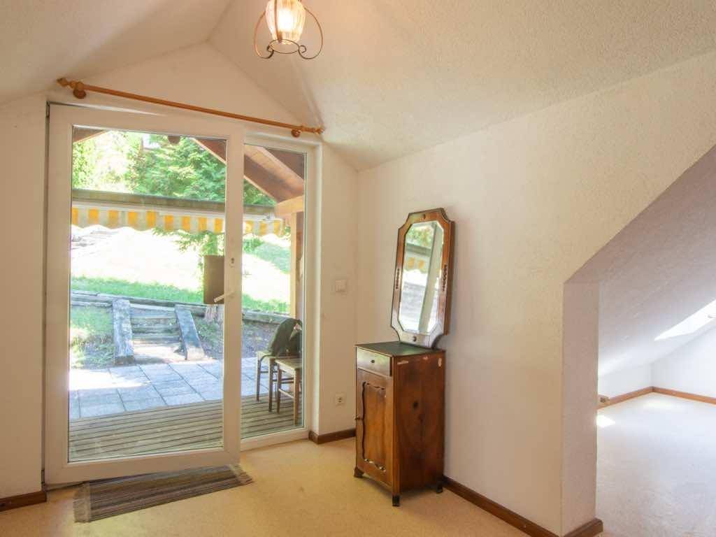 Heller Eingangsbereich mit Holzboden, einem antiken Spiegel und Zugang zur Terrasse.
