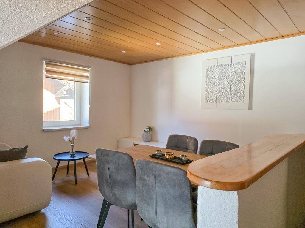 Gemütlicher Essbereich mit Holzdecke, modernem Esstisch und indirekter Beleuchtung.