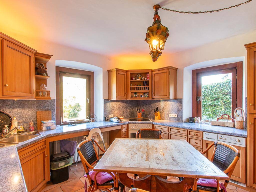 Traditionelle Holzküche mit Essbereich, Granitarbeitsplatten und Blick in den Garten.