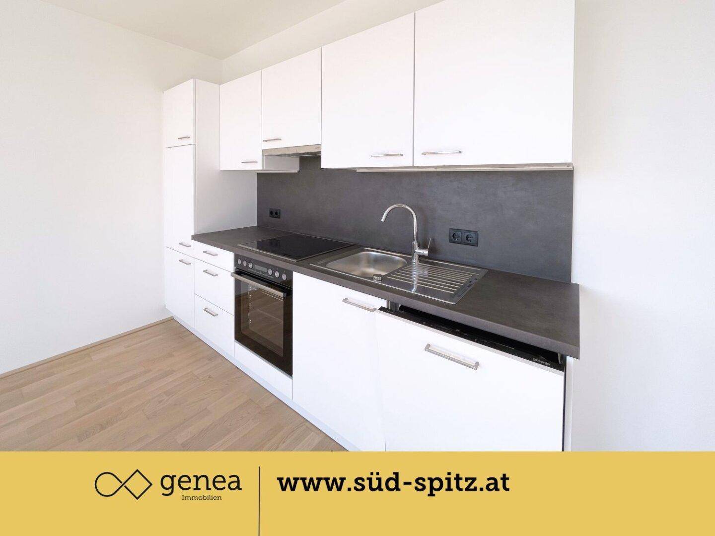 Moderne Einbauküche mit weißen Schränken, dunkler Arbeitsplatte und integrierten Geräten.