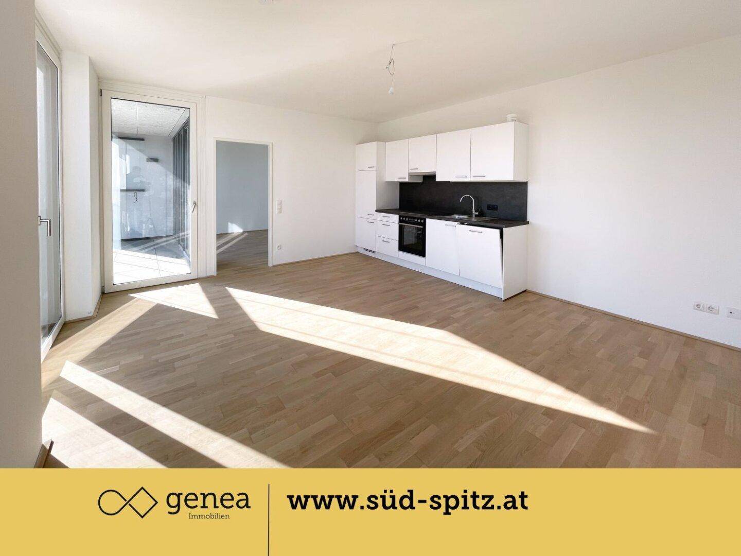 Geräumiger Wohn-Essbereich mit integrierter Küche, Parkettboden und viel Tageslicht.
