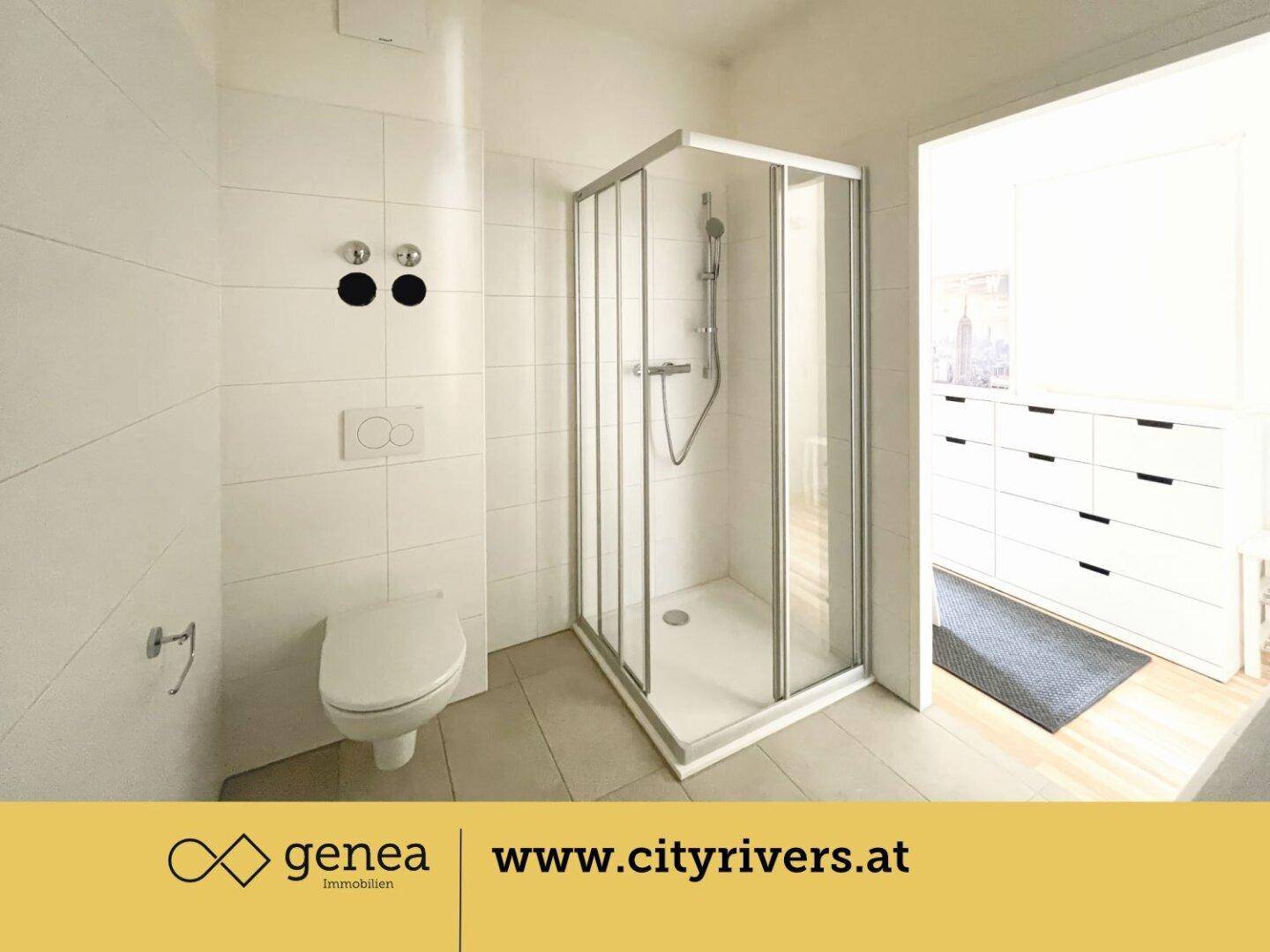 Modernes Badezimmer mit weiß gefliesten Wänden, einer Duschkabine und einem wandhängenden WC.