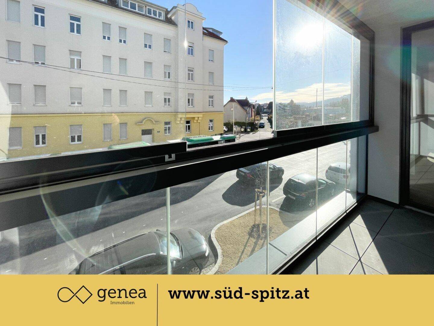Verglaste Loggia mit Blick auf die Straße und umliegende Gebäude.
