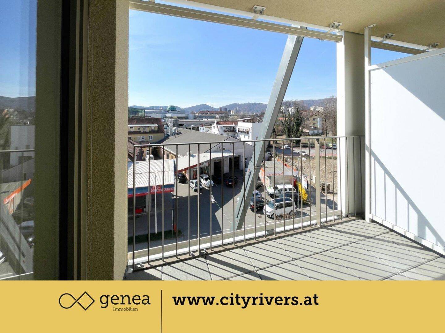 Blick von der Loggia auf die Umgebung mit Stadtansicht und fernen Hügeln.