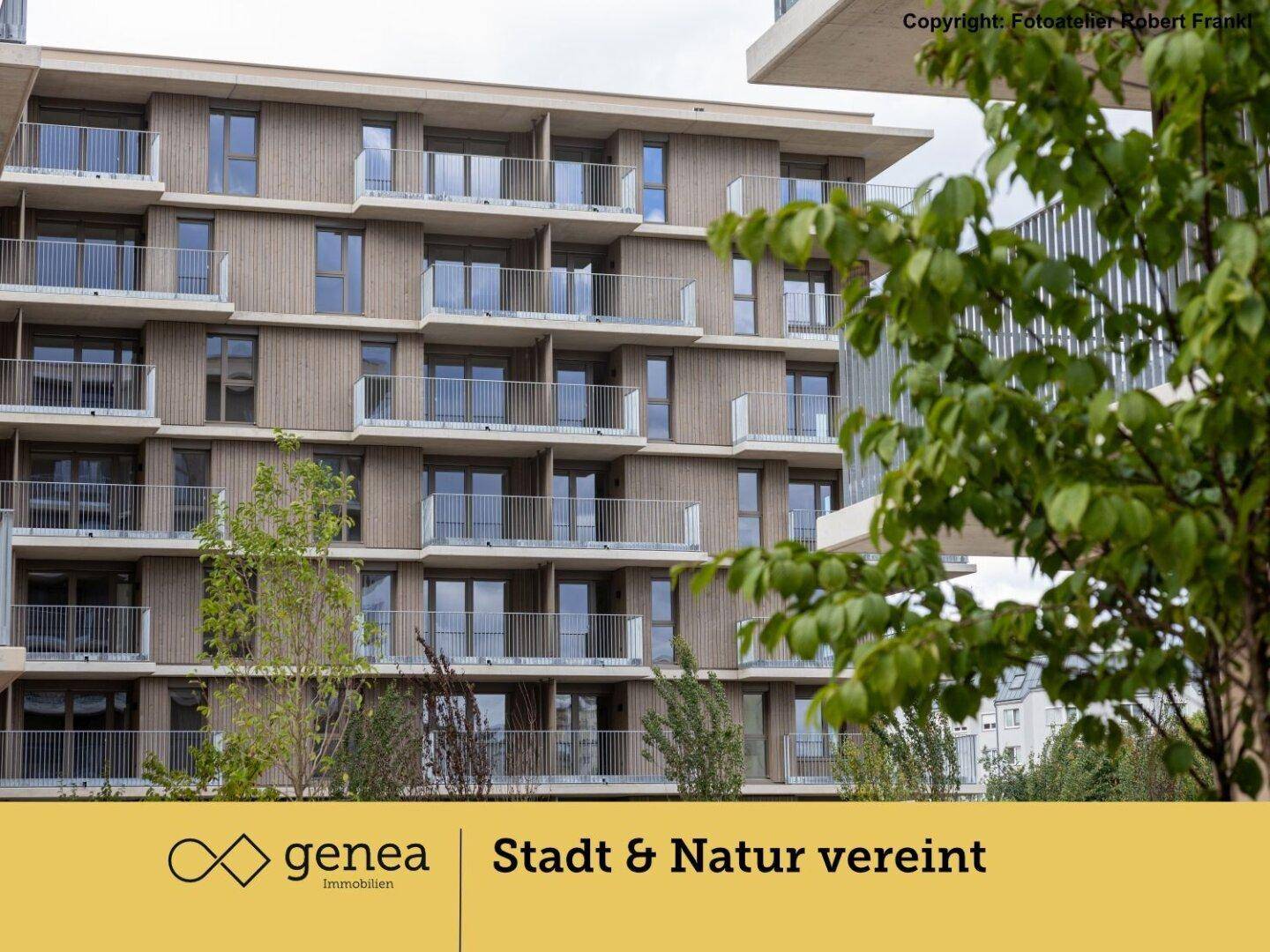 Modernes Mehrfamilienhaus mit Holzfassade, zahlreichen Balkonen und umgebender Grünfläche.