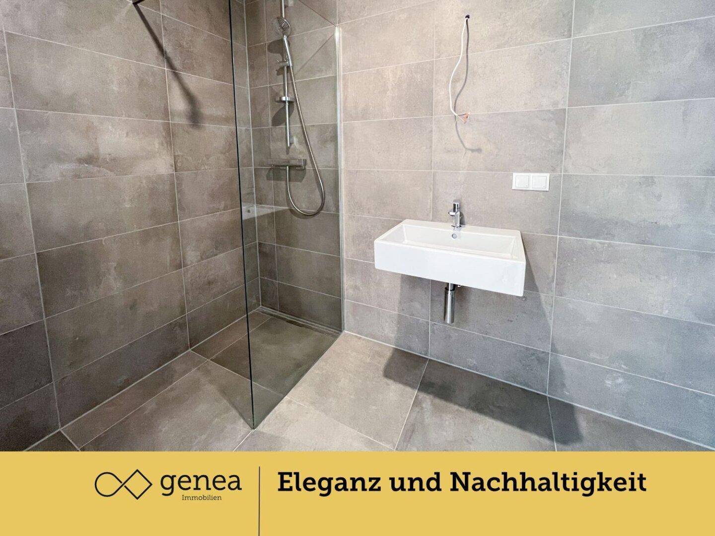 Modernes Badezimmer mit großer begehbarer Dusche und grauen Fliesen.