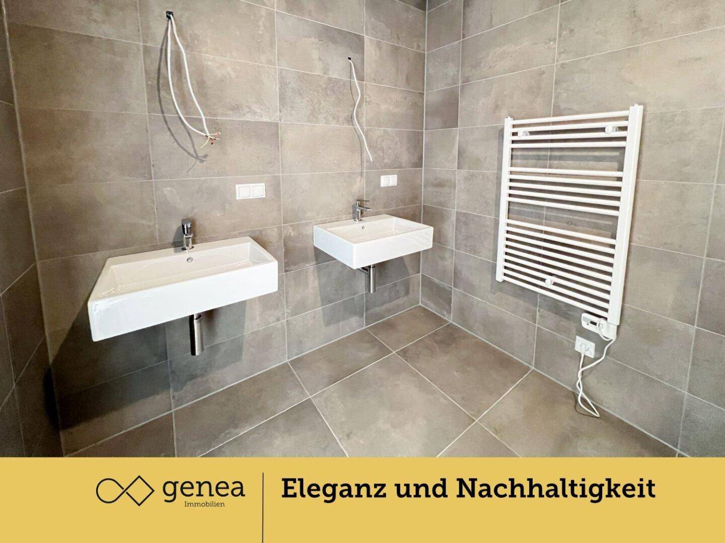 Modernes Badezimmer mit zwei Waschbecken und einem beheizten Handtuchhalter.
