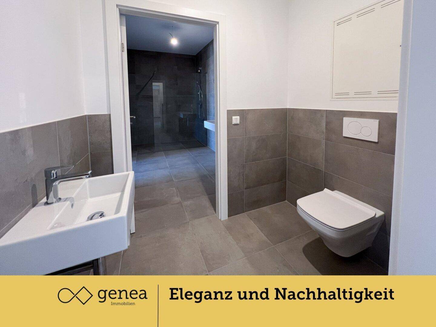 Modernes Badezimmer mit grauen Fliesen, wandhängendem WC und einem stilvollen Waschbecken.