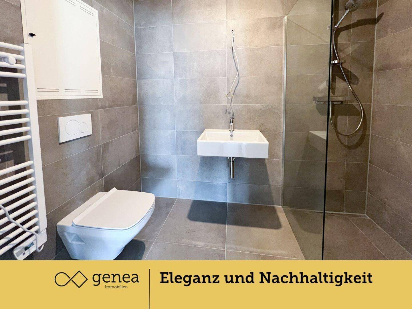 Modernes Badezimmer mit grauen Fliesen, wandhängendem WC und ebenerdiger Dusche.