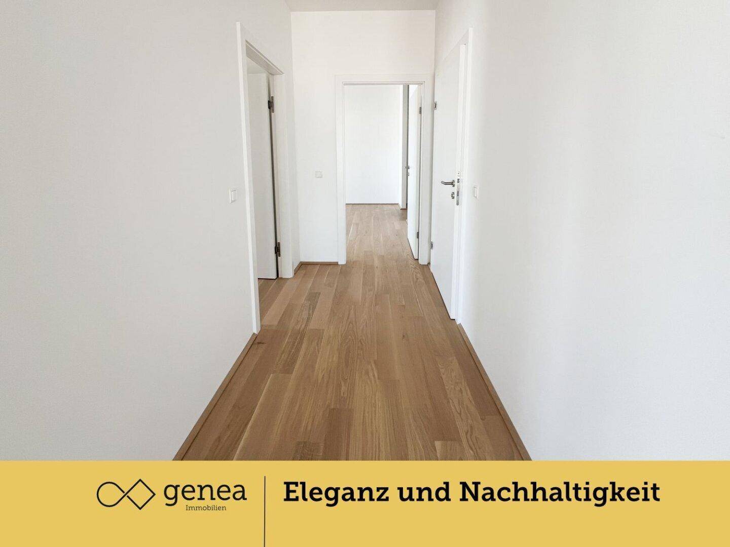 Langer, heller Flur mit Parkettboden und weißen Wänden, der zu weiteren Räumen führt.
