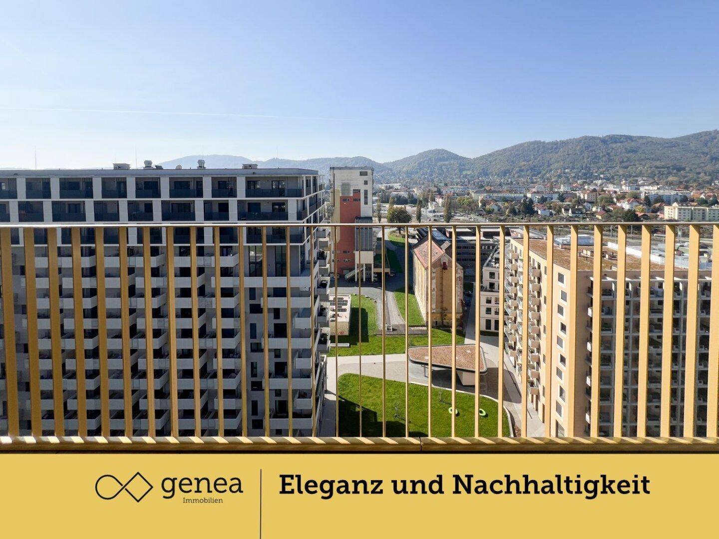 Blick vom Balkon auf moderne Gebäude und eine bergige Landschaft im Hintergrund.