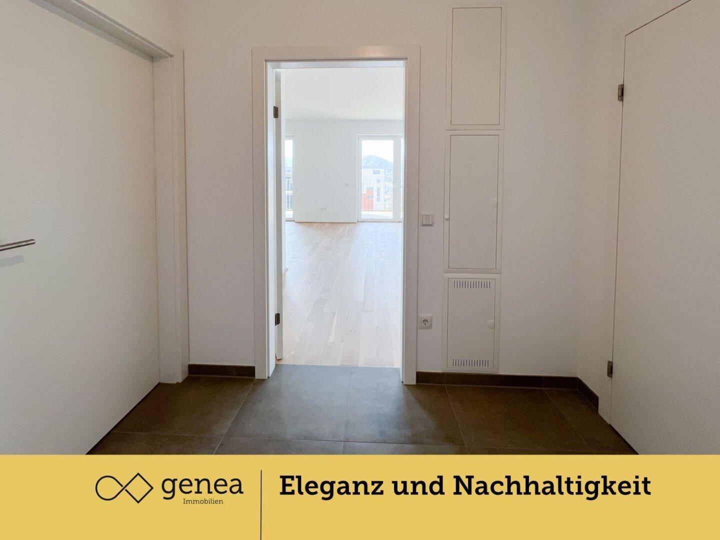 Eingangsbereich mit dunklen Fliesen und Blick in einen hellen Wohnraum.